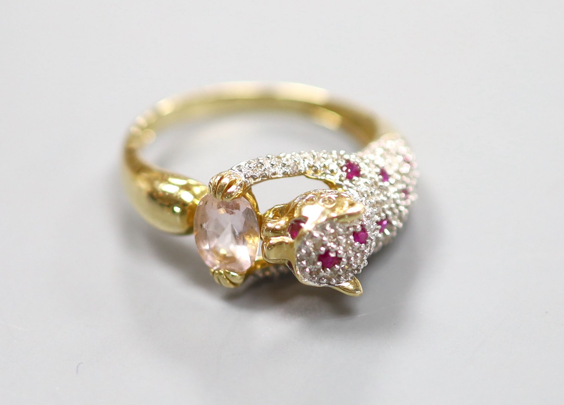 A modern Cartier style 585 yellow metal, pink topaz?, ruby and diamond encrusted leopard ring